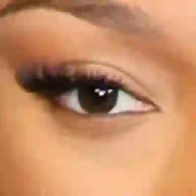 Megan Thee Stallion's eyes — warm dark amber-brown with golden depth